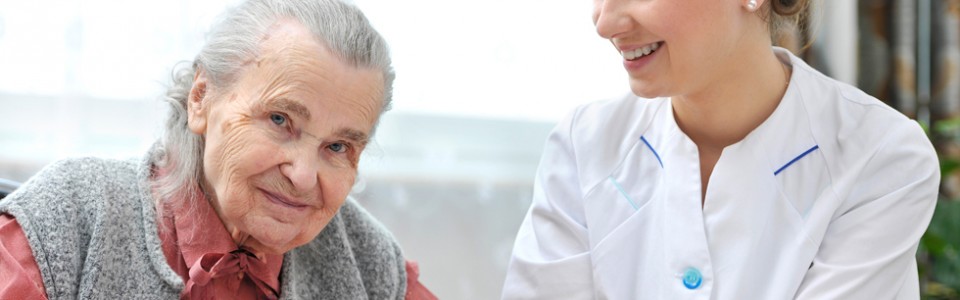 Nurse caring for elderly woman both smiling