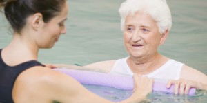 Woman trainer showing older woman hydrotherapy